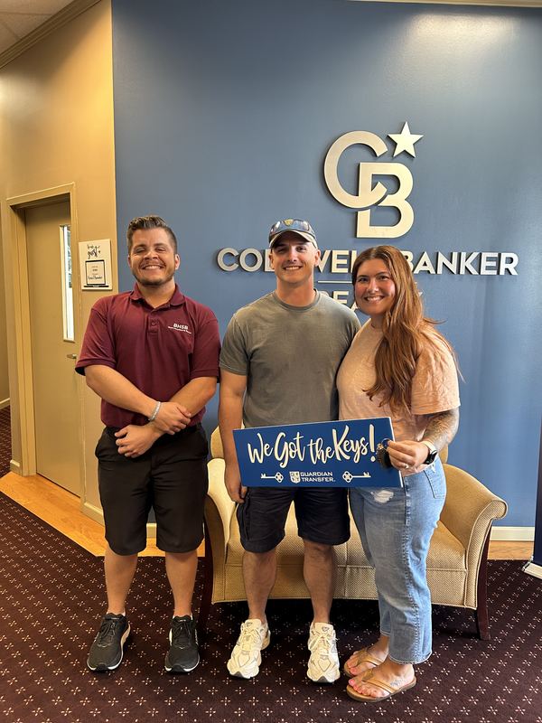 Couple with Bryce Barnes holding We Got the Keys sign Coldwell Banker Realty