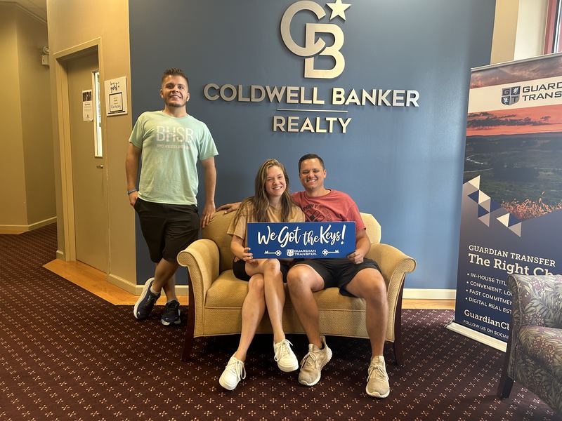 Clients holding We Got the Keys sign with Bryce Barnes BHSB Coldwell Banker Realty